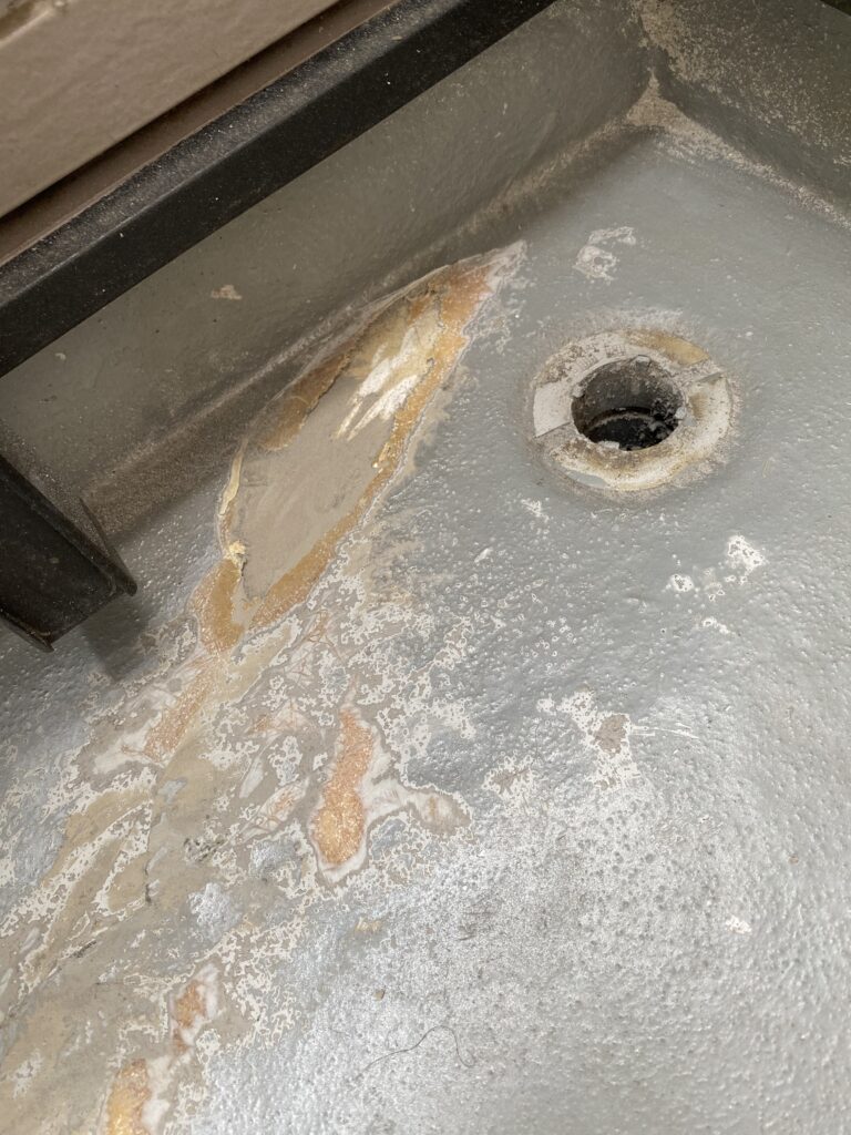 排水口周辺のFRP防水層が剥がれガラス繊維が露出した状態