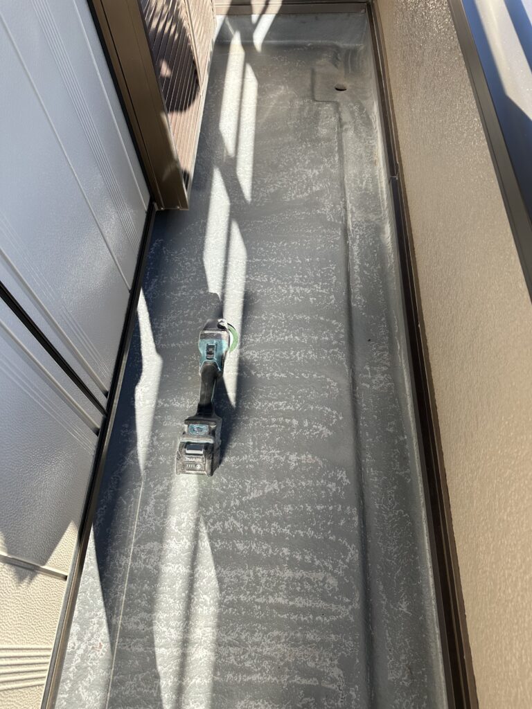 電動工具で既存のFRP防水面を研磨して下地処理している様子