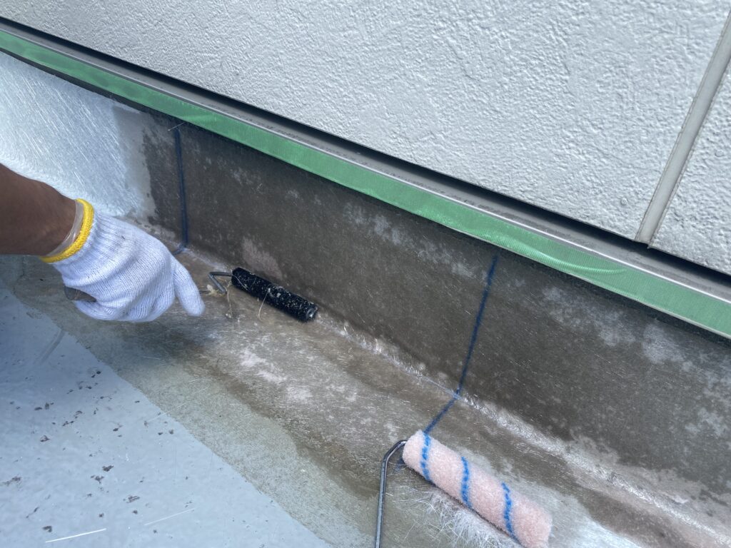 バルコニーの床と立ち上がりにガラスマットと樹脂を施工している工程